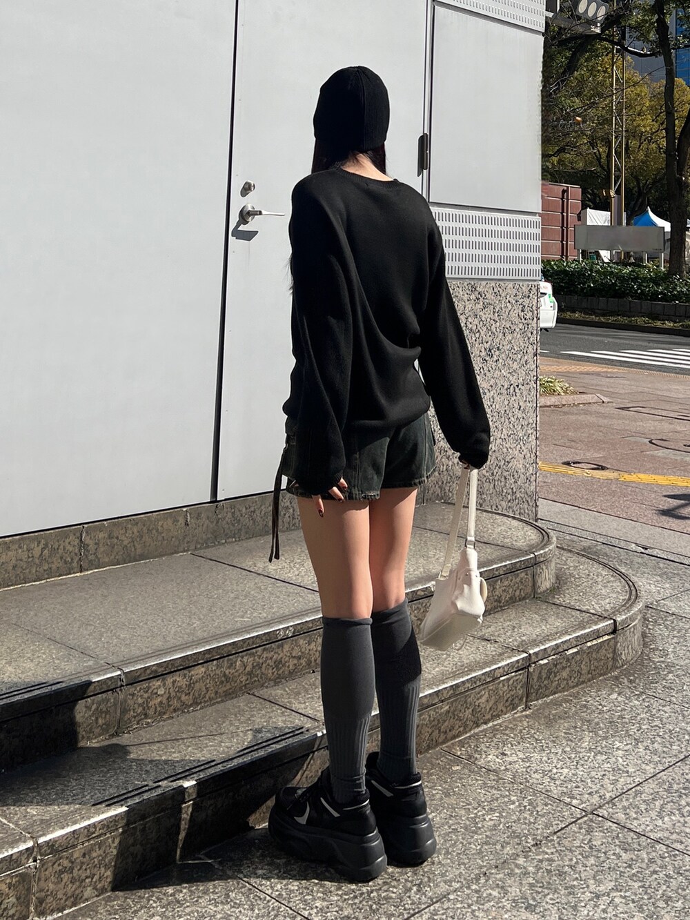 ブラック系のニット/セーター、ブルー系のその他パンツ、ブラック系のスニーカーを着用したレディースの春コーディネートの2枚目の写真