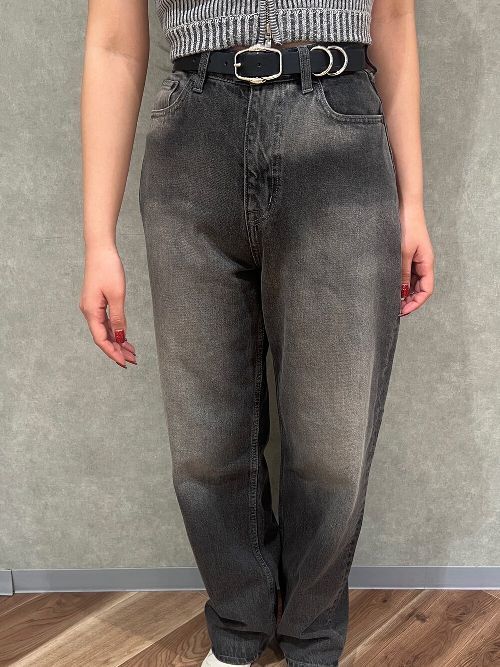 グレー系のニット/セーター、グレー系のデニムパンツ、ブラック系のサンダルを着用したレディースの春コーディネートの5枚目の写真