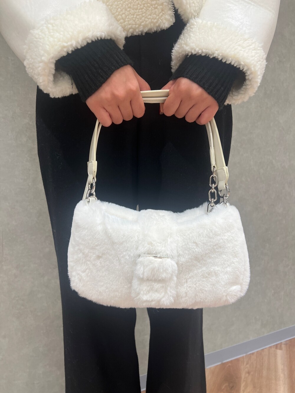 ホワイト系のブルゾン、ブラック系のその他パンツ、ブラック系のブーツを着用したレディースの冬コーディネートの4枚目の写真