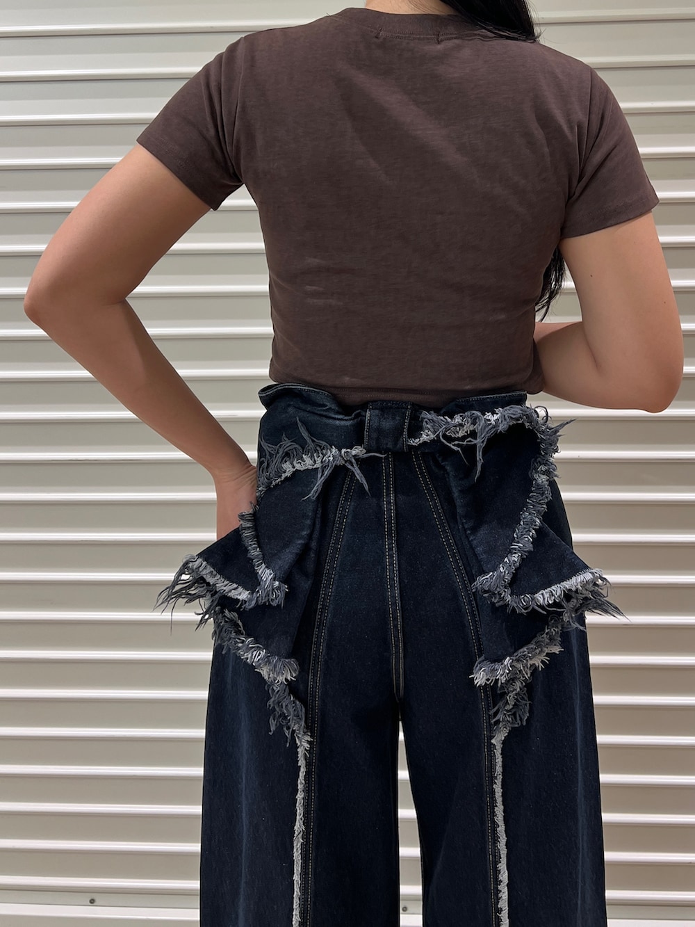 ブラウン系のTシャツ/カットソー、ブルー系のデニムパンツ、ブラック系のサンダルを着用したレディースの春コーディネートの3枚目の写真