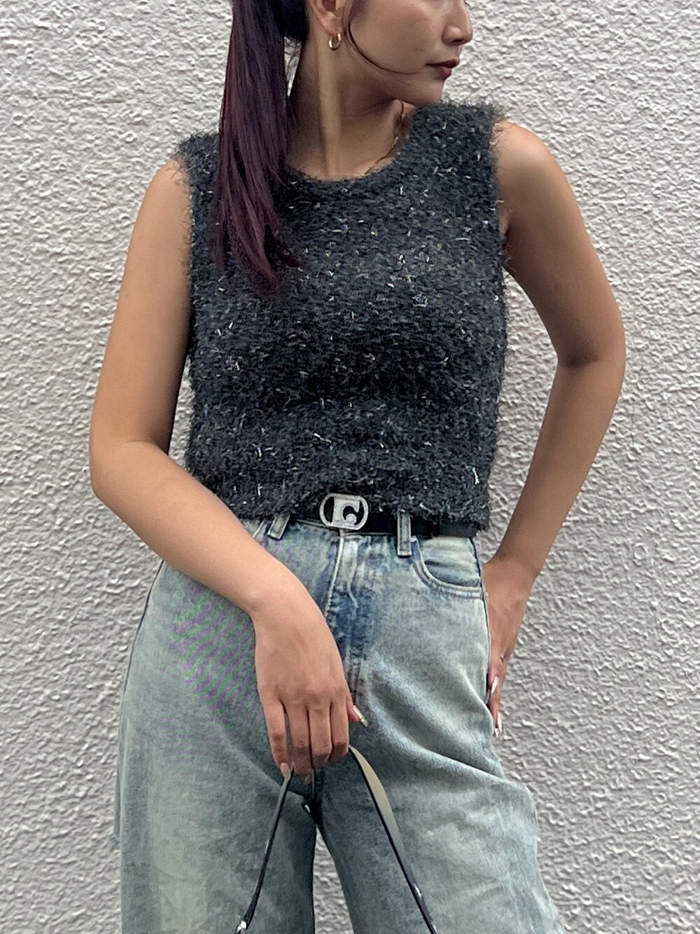 グレー系のタンクトップ、ブルー系のデニムパンツ、ブラック系のハンドバッグを着用したレディースの夏コーディネートの3枚目の写真