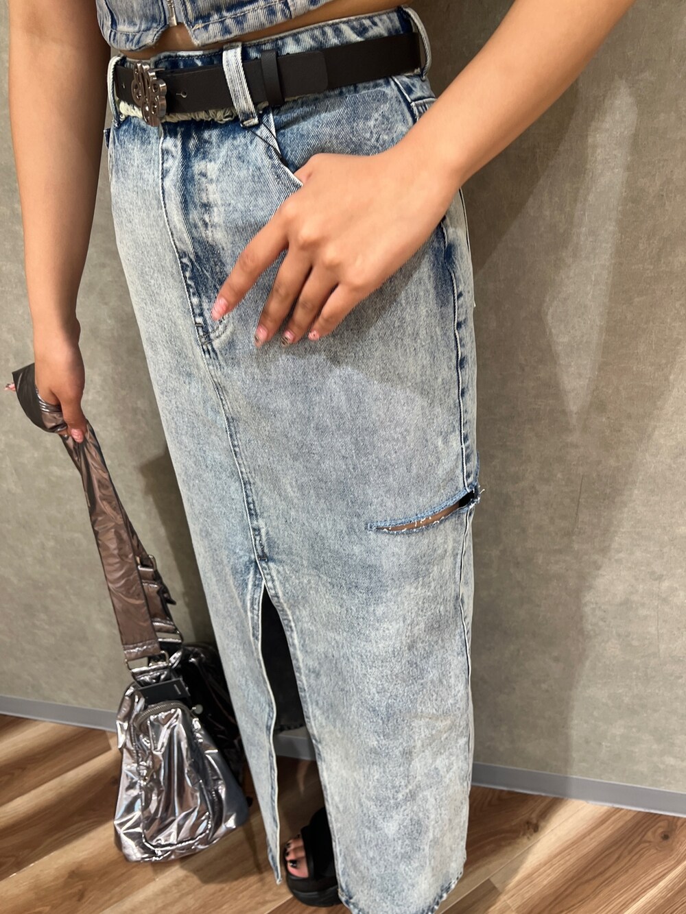 ブラック系のTシャツ/カットソー、ブルー系のデニムスカート、ブラック系のサンダルを着用したレディースの夏コーディネートの6枚目の写真