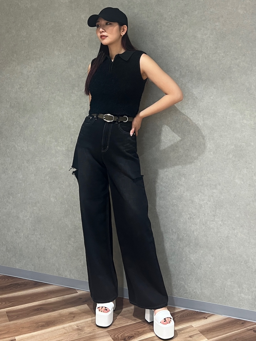 ブラック系のタンクトップ、ブラック系のデニムパンツ、ホワイト系のサンダルを着用したレディースの夏コーディネートの2枚目の写真