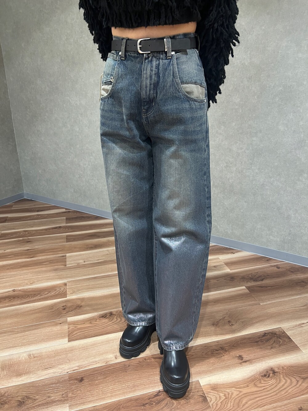 ブラック系のニット/セーター、ブルー系のデニムパンツ、ブラック系のブーツを着用したレディースの冬コーディネートの7枚目の写真