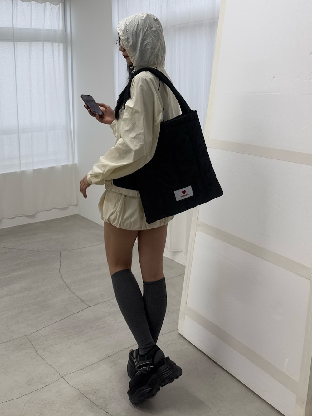 ホワイト系のブルゾン、ホワイト系のスカート、ブラック系のサンダルを着用したレディースの冬コーディネートの3枚目の写真