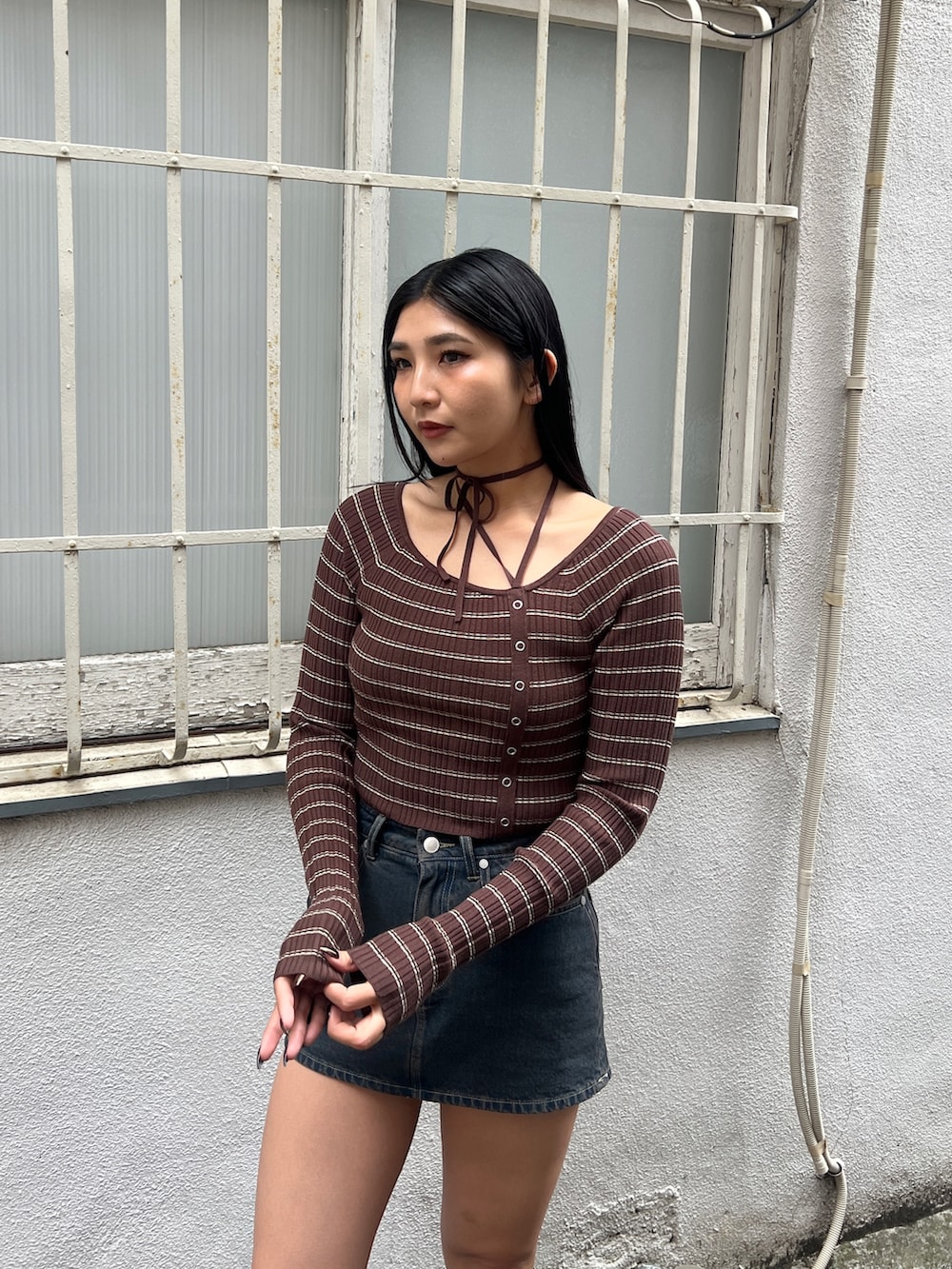 ブラウン系のニット/セーター、ブルー系のスカート、ブラック系のブーツを着用したレディースの冬コーディネートの4枚目の写真