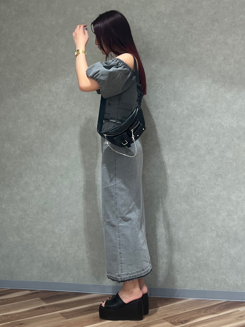 ブラック系のサンダル、グレー系のスカート、ブラック系のハンドバッグを着用したレディースの春コーディネートの2枚目の写真