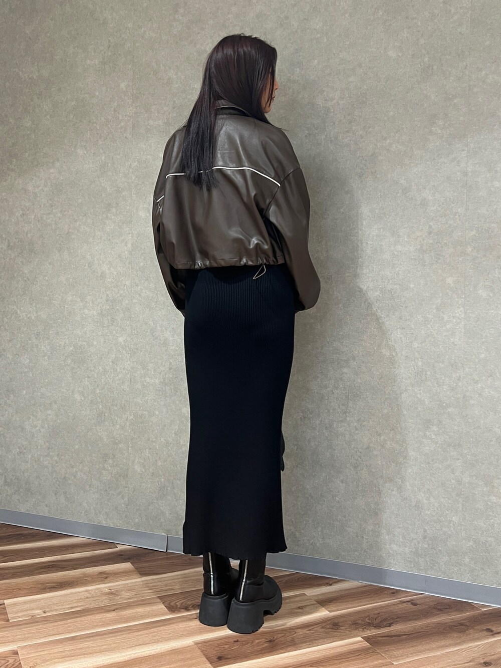 ブラウン系のブルゾン、ブラック系のワンピース、ブラック系のハンドバッグを着用したレディースの冬コーディネートの3枚目の写真