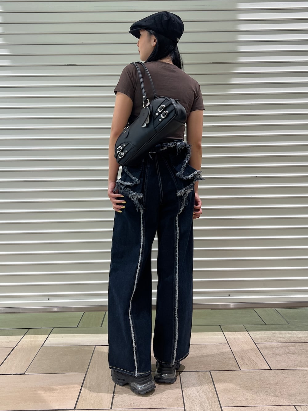 ブラウン系のTシャツ/カットソー、ブルー系のデニムパンツ、ブラック系のサンダルを着用したレディースの春コーディネートの6枚目の写真