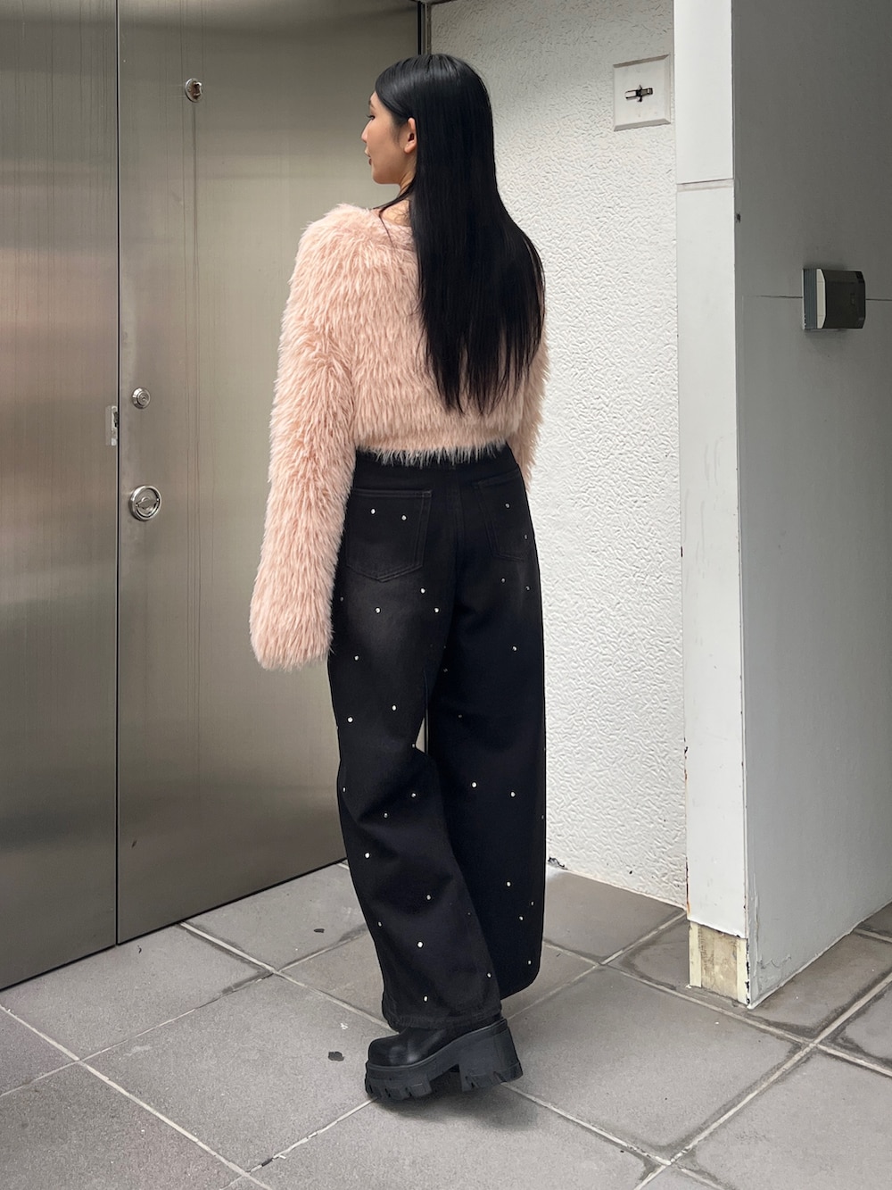 ピンク系のニット/セーター、ブルー系のデニムパンツ、ブラウン系のブーツを着用したレディースの冬コーディネートの3枚目の写真