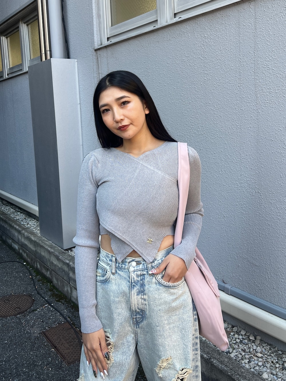 グレー系のニット/セーター、ブルー系のデニムパンツ、ブラック系のサンダルを着用したレディースの冬コーディネートの4枚目の写真