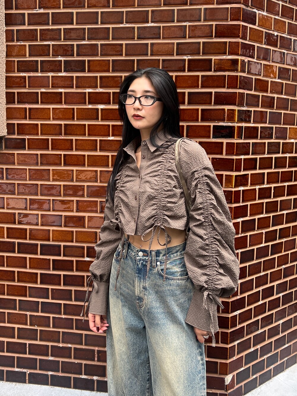 ブラウン系のシャツ/ブラウス、ブルー系のデニムパンツ、ブラック系のローファーを着用したレディースの秋コーディネートの3枚目の写真