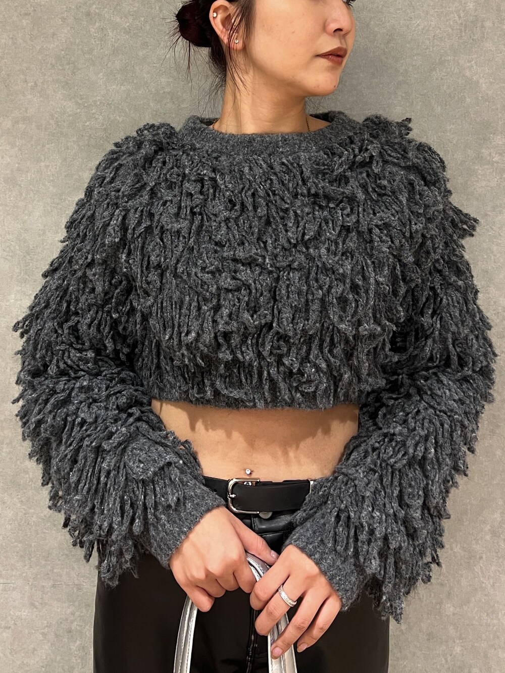 ブラック系のその他パンツ、グレー系のニット/セーター、シルバー系のショルダーバッグを着用したレディースの秋コーディネートの4枚目の写真