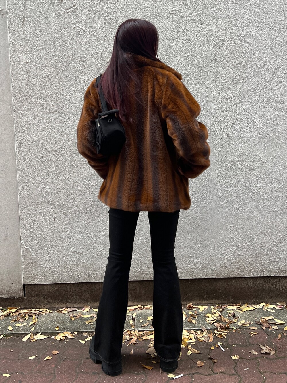 ブラウン系のその他アウター、ブラック系のニット/セーター、ブラック系のデニムパンツを着用したレディースの冬コーディネートの3枚目の写真