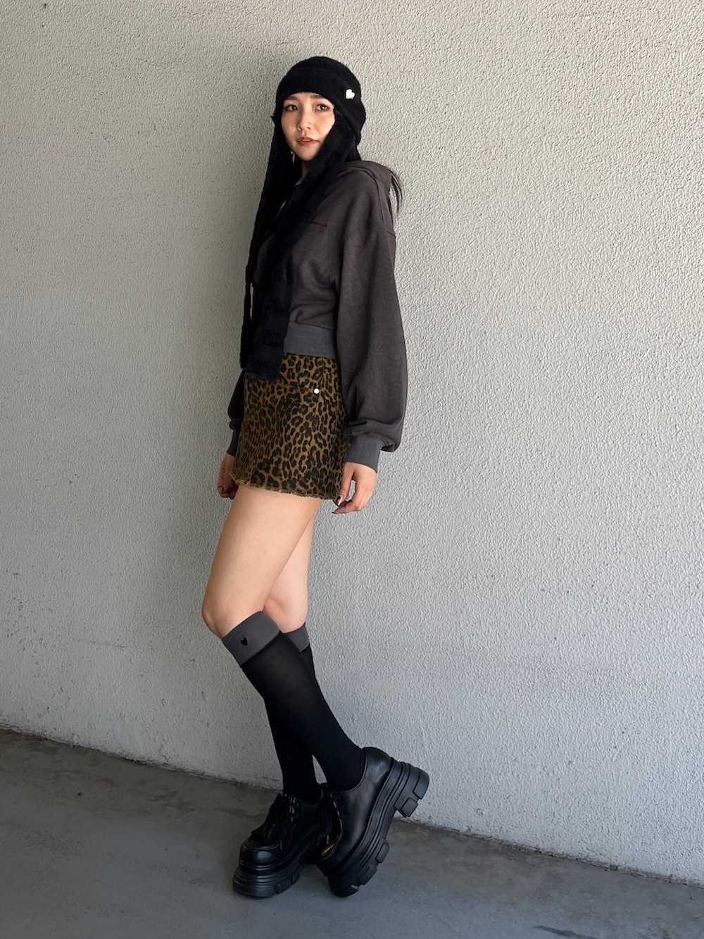 ブラック系のパーカー、ベージュ系のスカート、ブラック系のローファーを着用したレディースの夏コーディネートの2枚目の写真