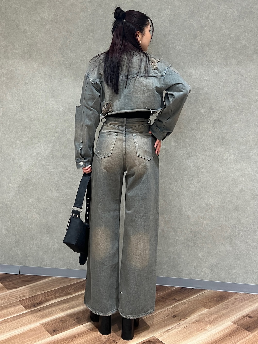 グレー系のデニムジャケット、グレー系のデニムパンツ、ブラック系のブーツを着用したレディースの冬コーディネートの3枚目の写真