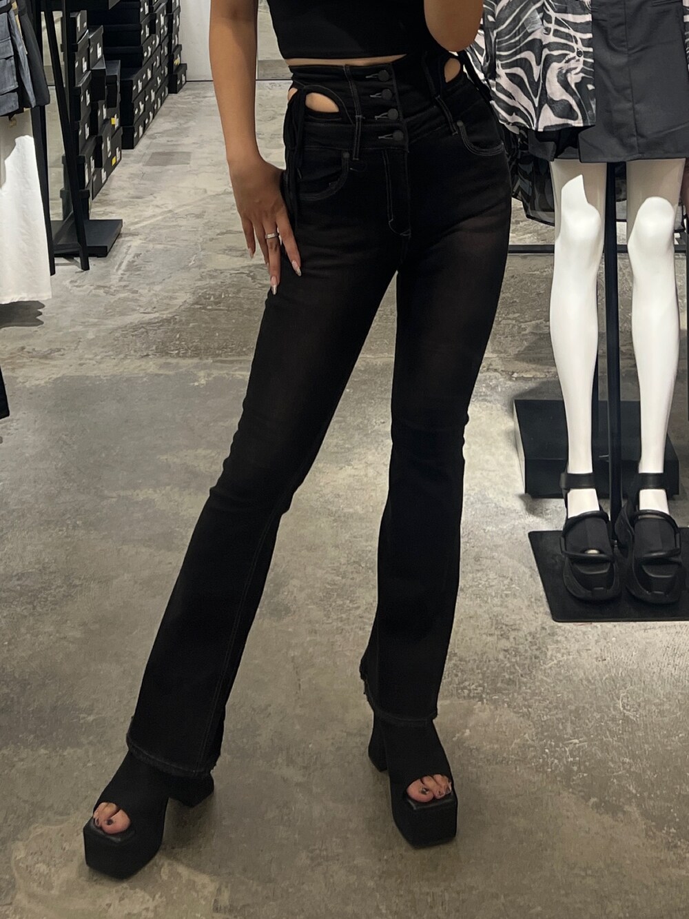 ブラック系のタンクトップ、ブラック系のデニムパンツ、ブラック系のサンダルを着用したレディースの夏コーディネートの6枚目の写真
