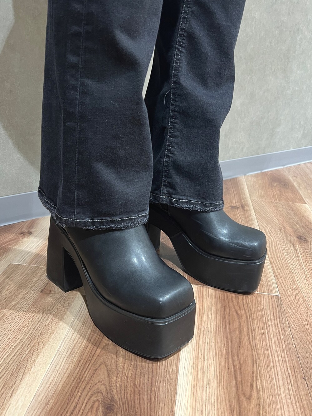 グレー系のピーコート、ブラック系のニット/セーター、ブラック系のデニムパンツを着用したレディースの秋コーディネートの7枚目の写真