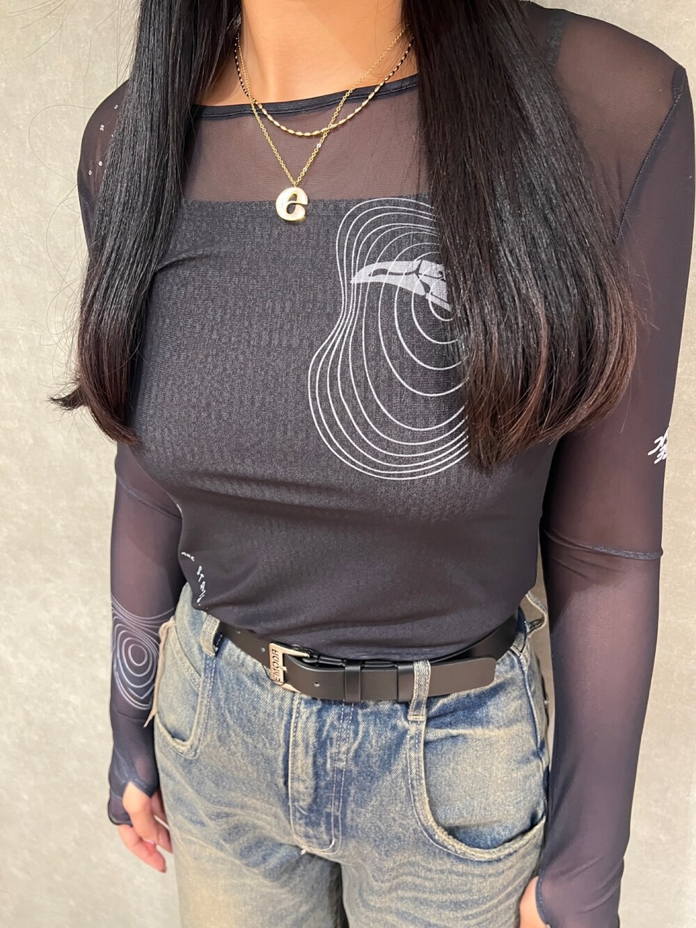 ブラック系のTシャツ/カットソー、ブルー系のデニムパンツ、ブラック系のブーツを着用したレディースの秋コーディネートの5枚目の写真