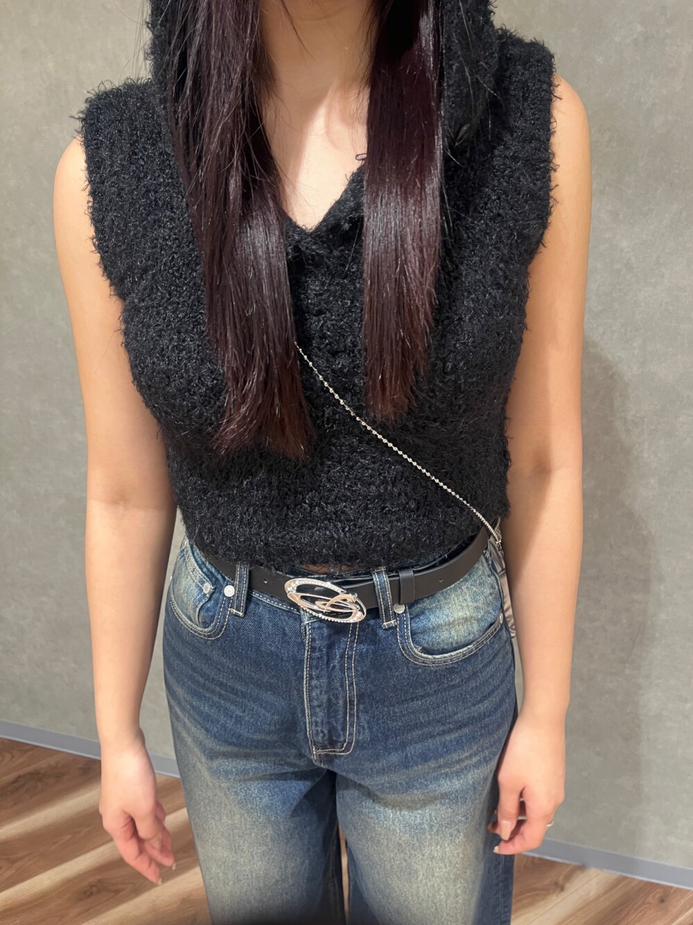 ブラック系のニット/セーター、ブルー系のデニムパンツ、ブラック系のパンプスを着用したレディースの春コーディネートの4枚目の写真