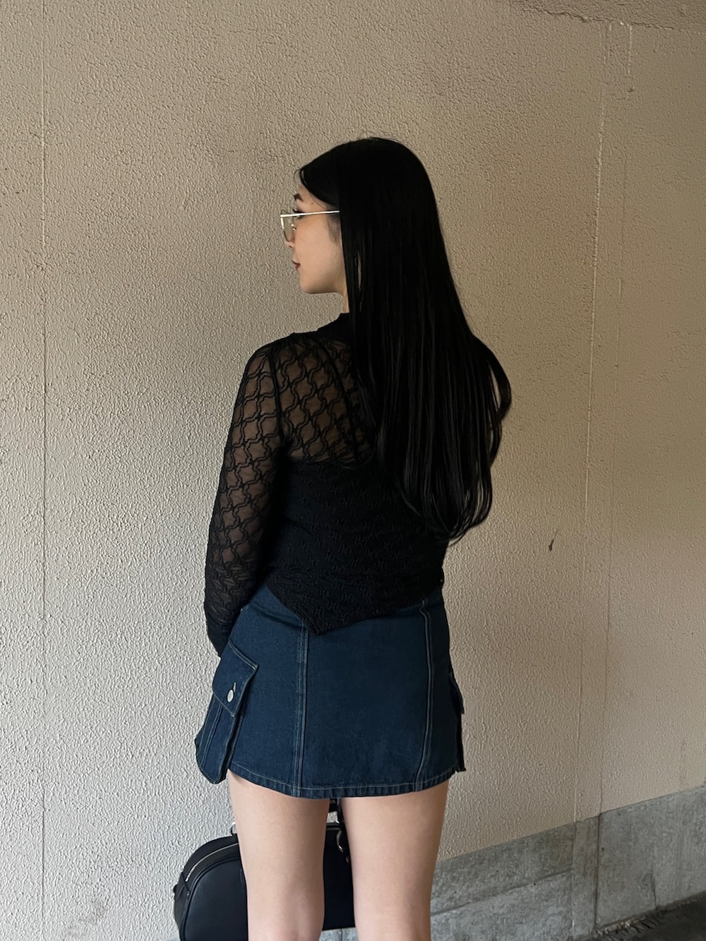 ブラック系のTシャツ/カットソー、ブルー系のスカート、ブラック系のサンダルを着用したレディースの春コーディネートの3枚目の写真