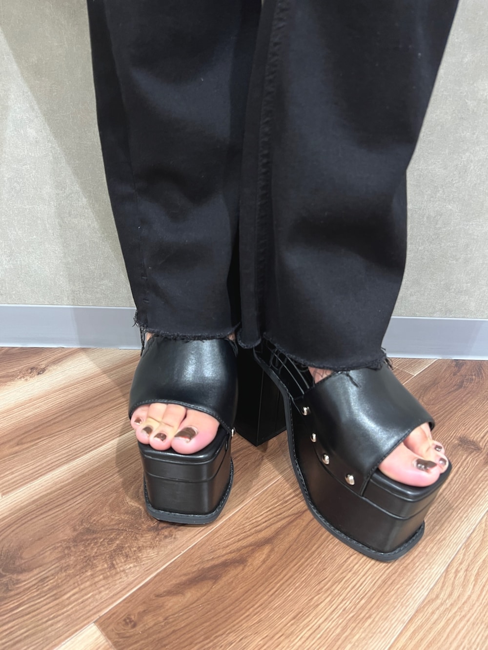 ブラック系のニット/セーター、ブラック系のデニムパンツ、ブラック系のサンダルを着用したレディースの夏コーディネートの5枚目の写真