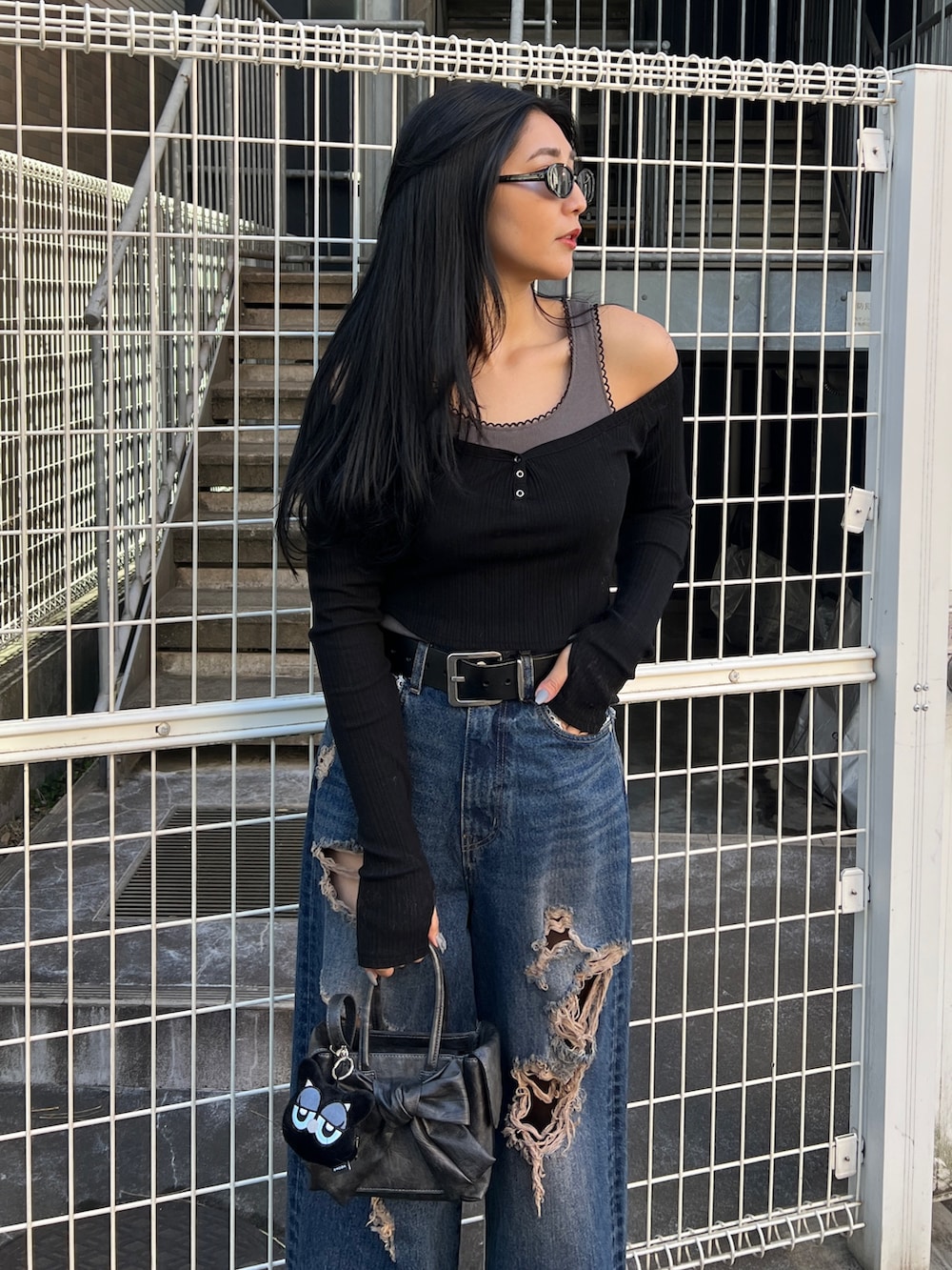 ブラック系のTシャツ/カットソー、ブルー系のデニムパンツ、ブラック系のハンドバッグを着用したレディースの春コーディネートの3枚目の写真