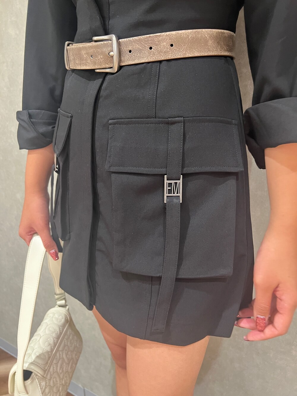 ブラック系のワンピース、ブラック系のブーツ、ホワイト系のハンドバッグを着用したレディースの秋コーディネートの5枚目の写真