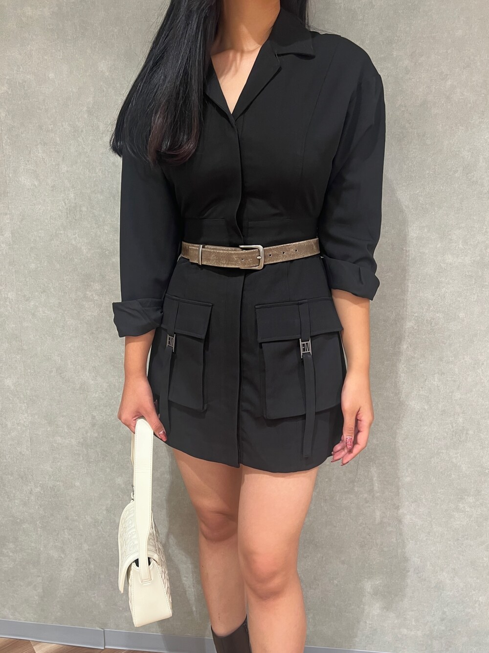 ブラック系のワンピース、ブラック系のブーツ、ホワイト系のハンドバッグを着用したレディースの秋コーディネートの4枚目の写真