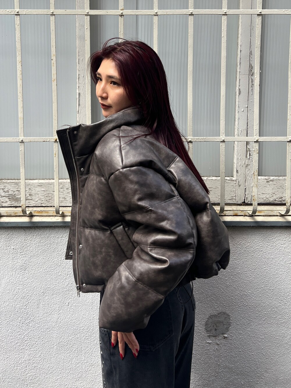 ブラウン系のダウンジャケット/コート、ブラック系のニット/セーター、ブラック系のデニムパンツを着用したレディースの秋コーディネートの4枚目の写真