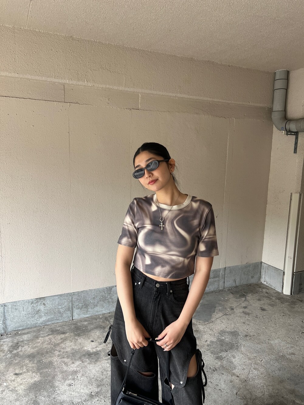 ベージュ系のTシャツ/カットソー、ブラック系のデニムパンツ、ブラック系のサンダルを着用したレディースの春コーディネートの3枚目の写真