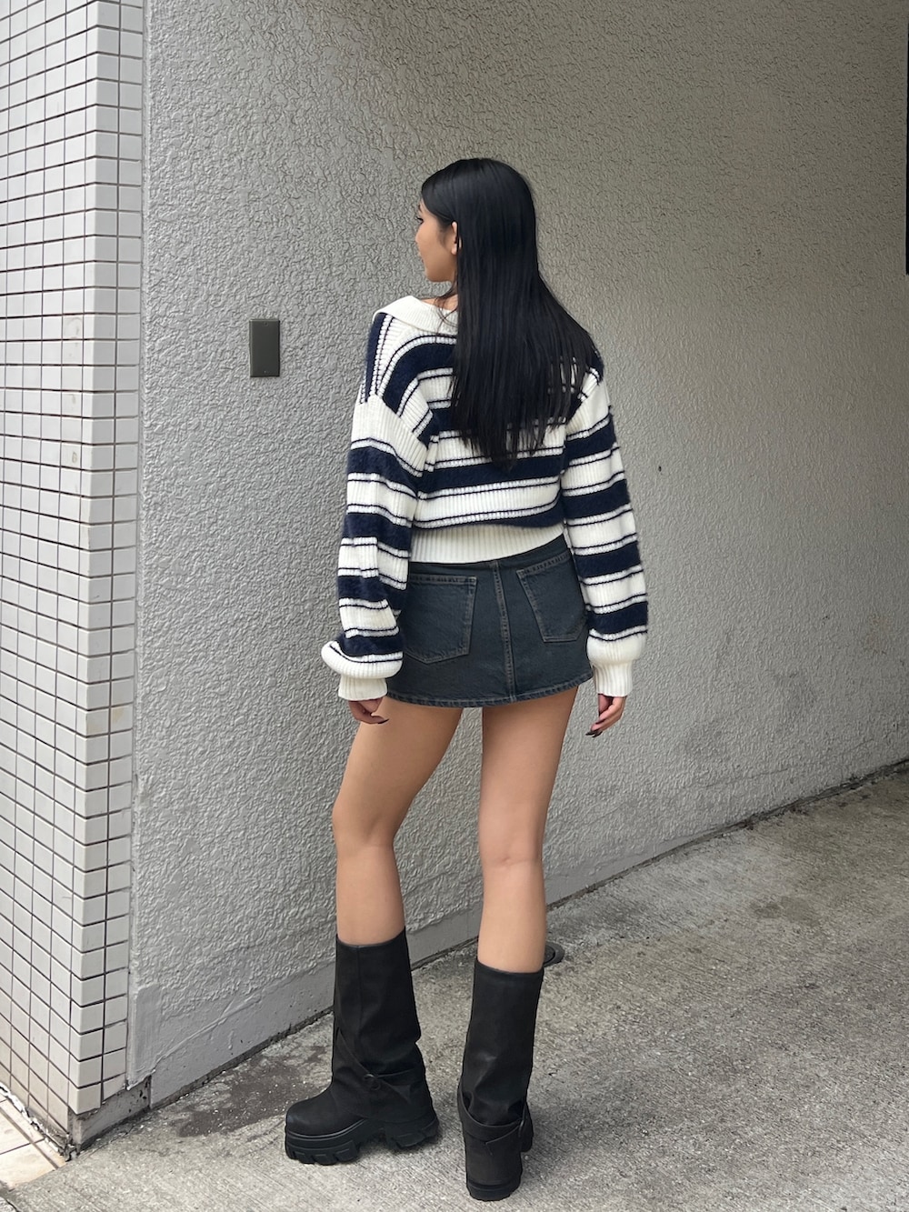 ブルー系のニット/セーター、ブルー系のスカート、ブラック系のブーツを着用したレディースの冬コーディネートの3枚目の写真