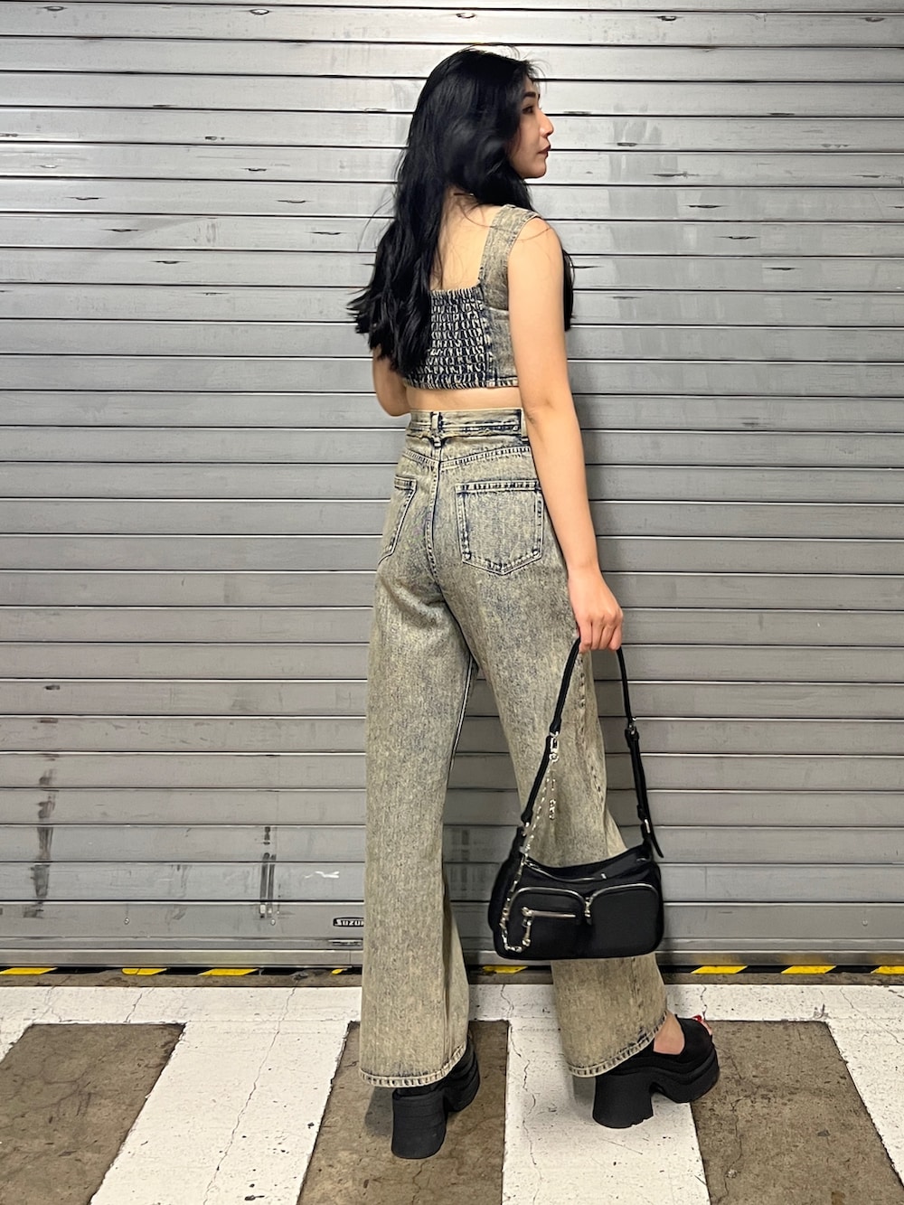 ベージュ系のデニムパンツ、ブラック系のハンドバッグ、ブラック系のサンダルを着用したレディースの夏コーディネートの2枚目の写真