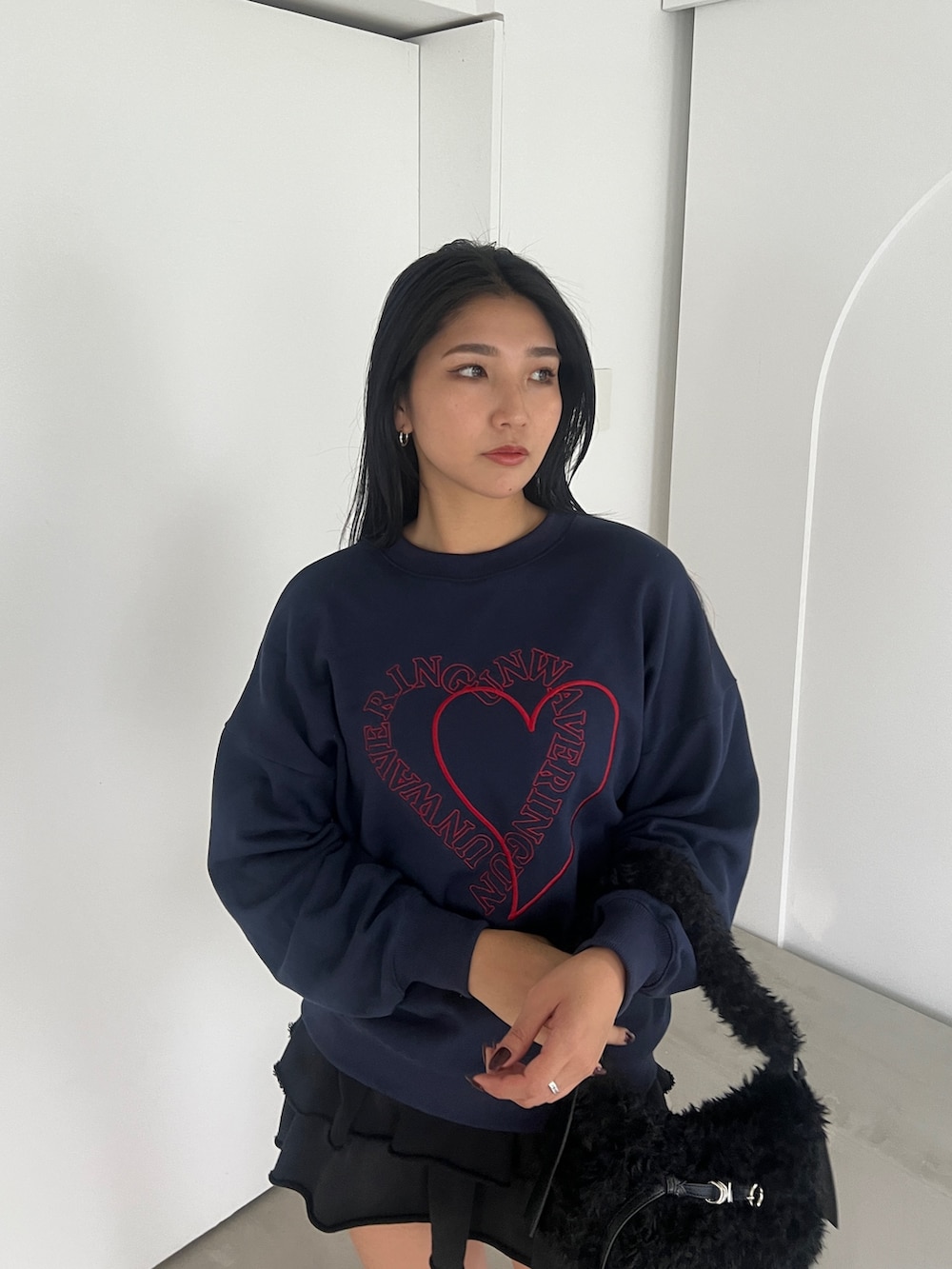 ブルー系のスウェット、ブラック系のスカート、ブラック系のブーツを着用したレディースの秋コーディネートの3枚目の写真