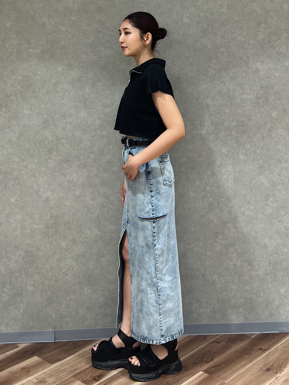 ブラック系のTシャツ/カットソー、ブルー系のデニムスカート、ブラック系のサンダルを着用したレディースの夏コーディネートの3枚目の写真