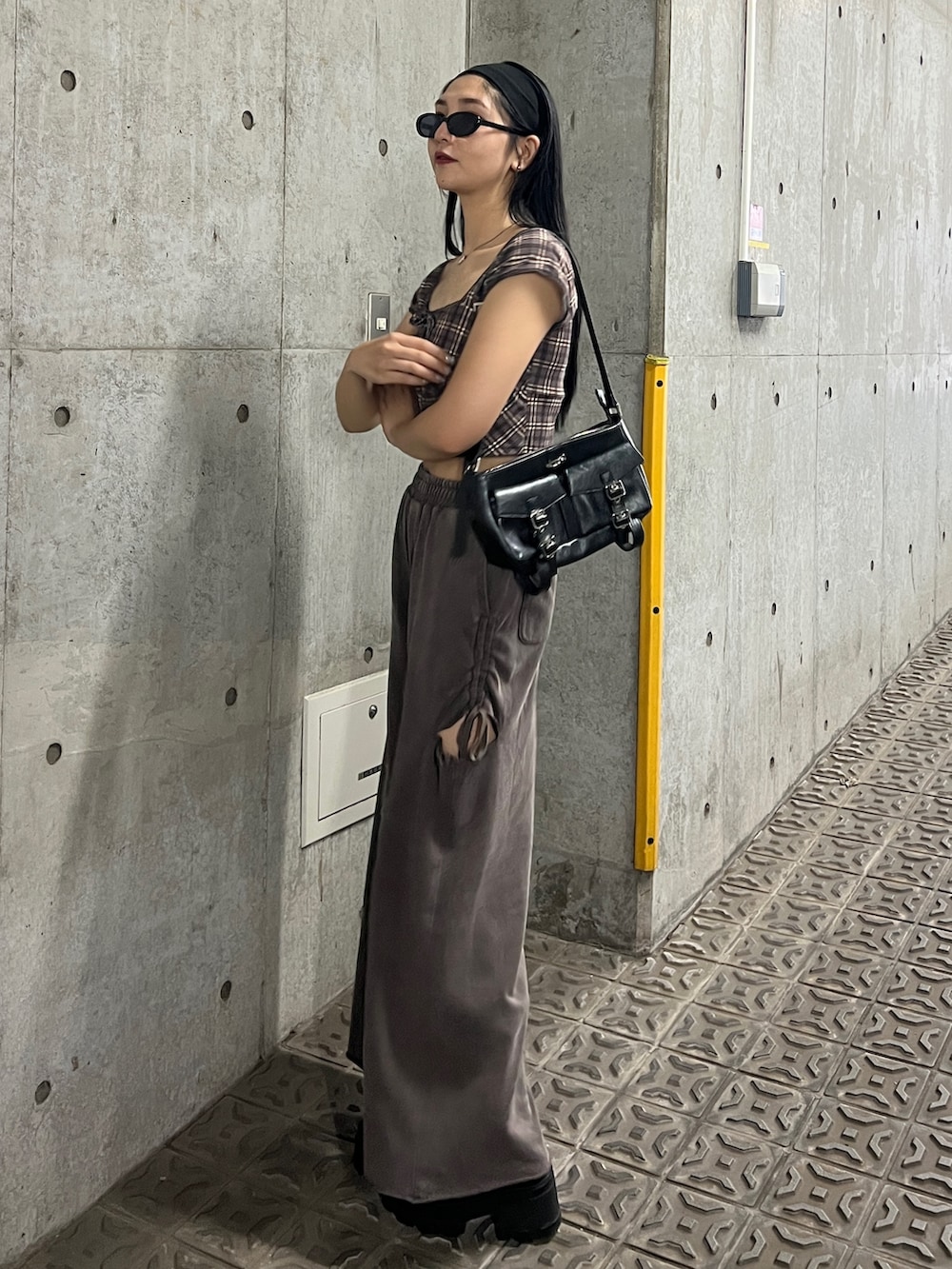 ブラウン系のタンクトップ、ブラウン系のスウェットパンツ、ブラック系のブーツを着用したレディースの夏コーディネートの2枚目の写真