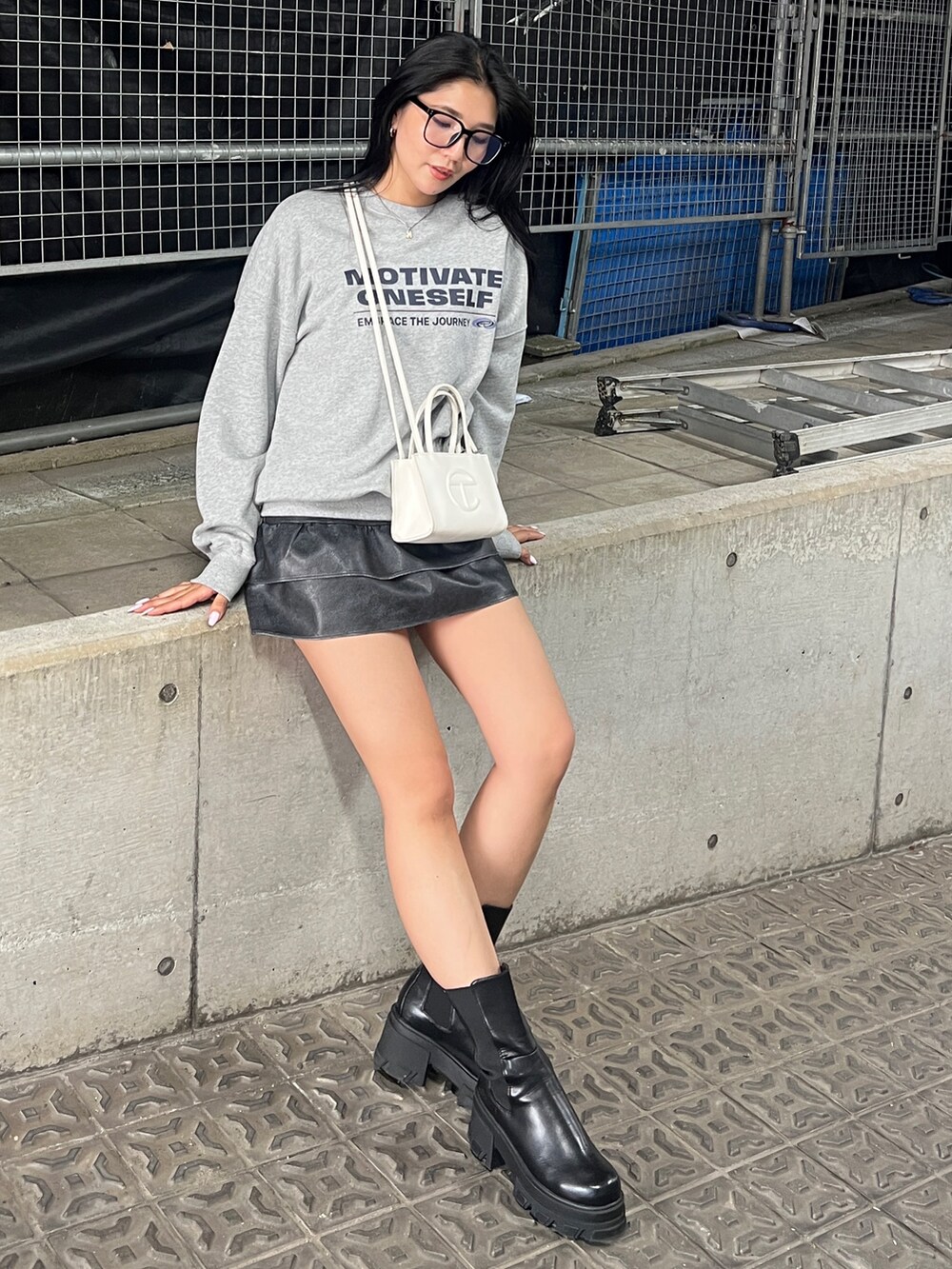 ブラック系のブルゾン、ブラック系のスカート、ブラック系のブーツを着用したレディースの秋コーディネートの4枚目の写真