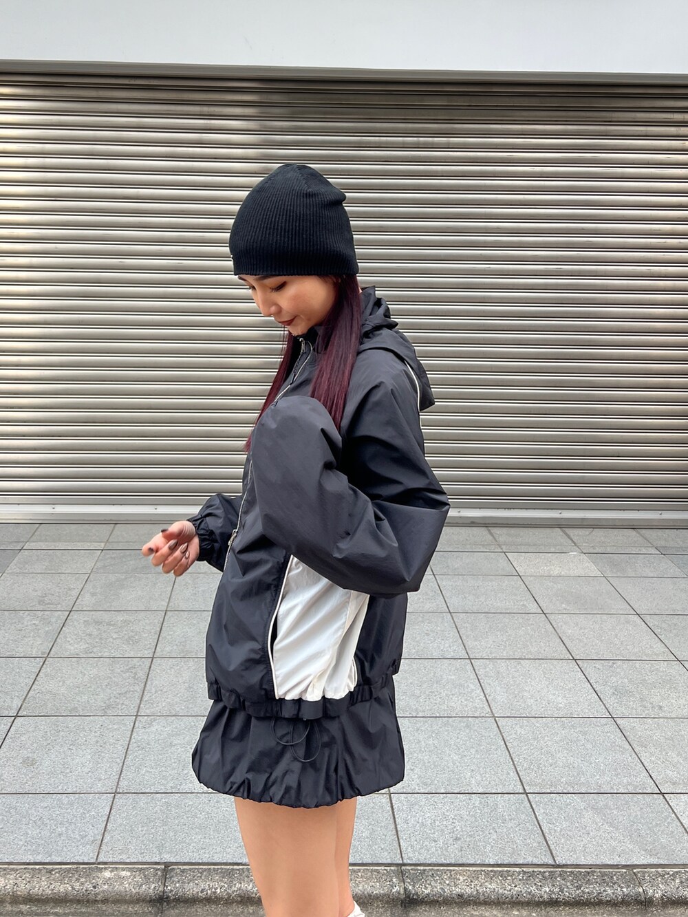 ブラック系のブルゾン、ブラック系のスカート、ホワイト系のスニーカーを着用したレディースの冬コーディネートの6枚目の写真