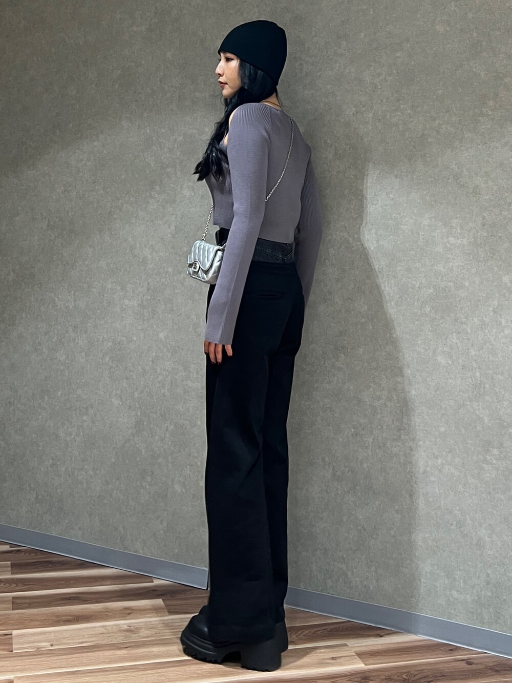 グレー系のニット/セーター、ブラック系のデニムパンツ、ブラック系のブーツを着用したレディースの冬コーディネートの2枚目の写真