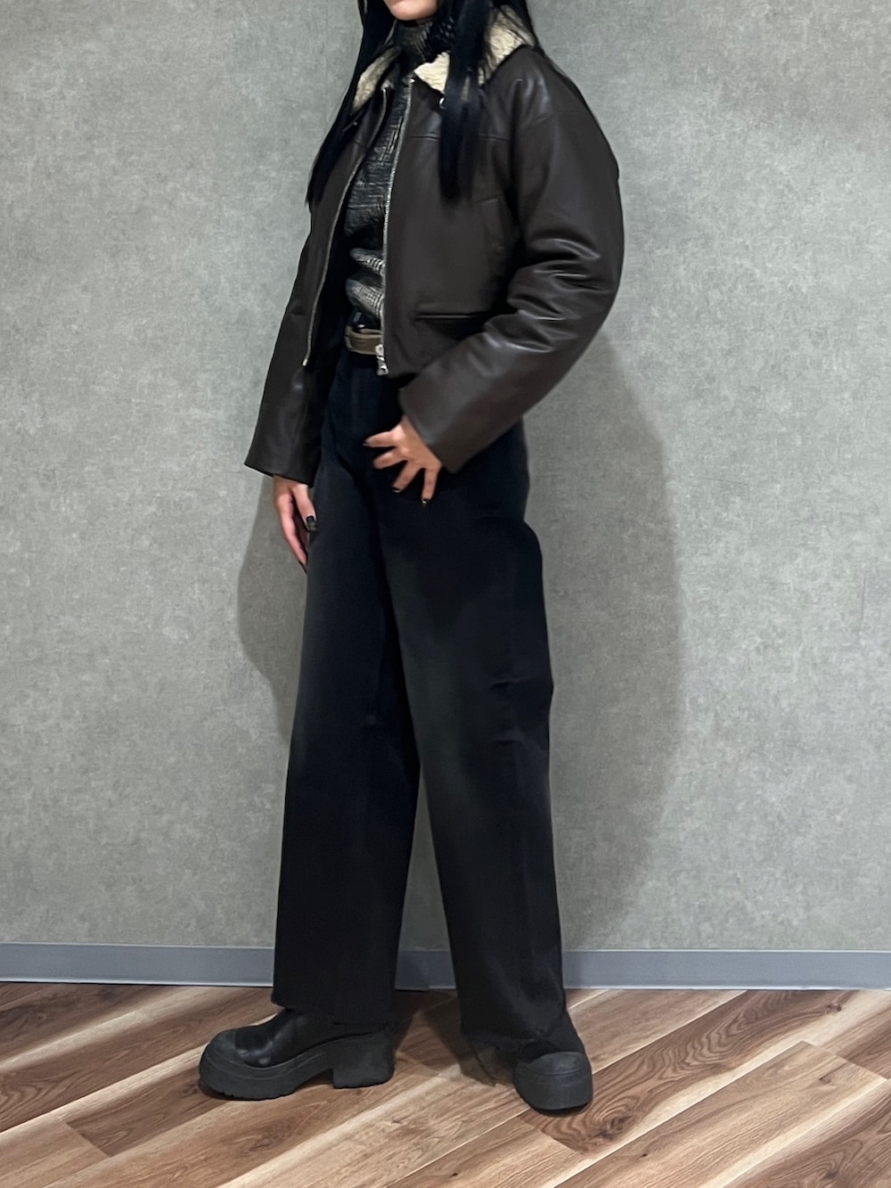 ブラウン系のブルゾン、ブラック系のニット/セーター、ブラック系のデニムパンツを着用したレディースの秋コーディネートの2枚目の写真