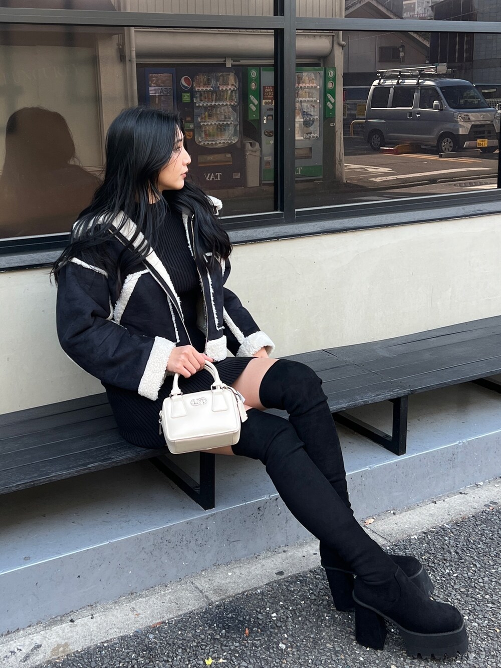 ブラック系のワンピース、ブラック系のブーツ、その他のブルゾンを着用したレディースの冬コーディネートの5枚目の写真