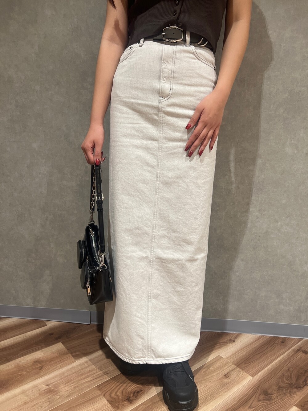 ブラウン系のチューブトップ、ホワイト系のTシャツ/カットソー、ブラック系のショルダーバッグを着用したレディースの春コーディネートの6枚目の写真