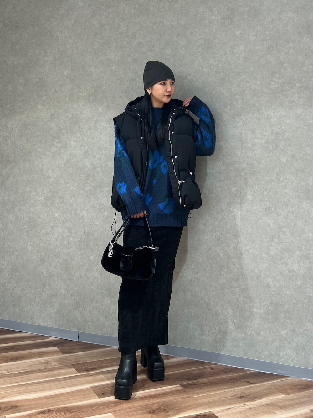 ブルー系のニット/セーター、ブラック系のブルゾン、ブラック系のスカートを着用したレディースの秋コーディネートの2枚目の写真