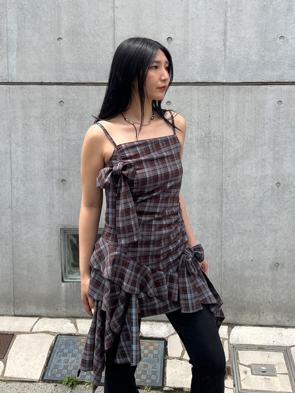 ブラウン系のワンピース、ブラック系のデニムパンツ、イエロー系のその他シューズを着用したレディースの夏コーディネートの4枚目の写真
