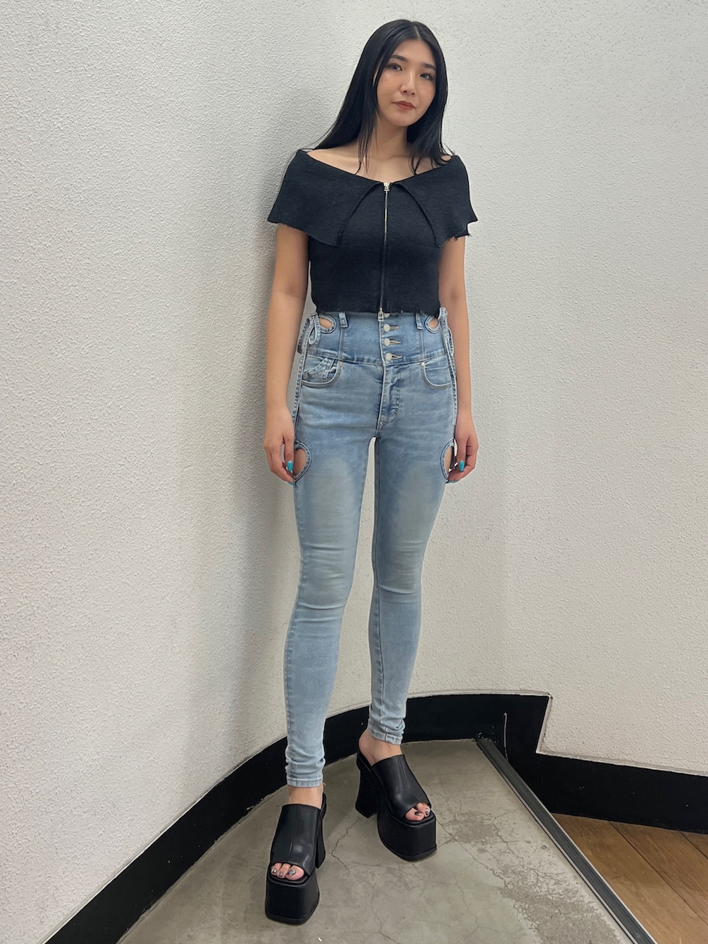 ブラック系のニット/セーター、ブルー系のデニムパンツ、ブラック系のサンダルを着用したレディースの春コーディネートの2枚目の写真