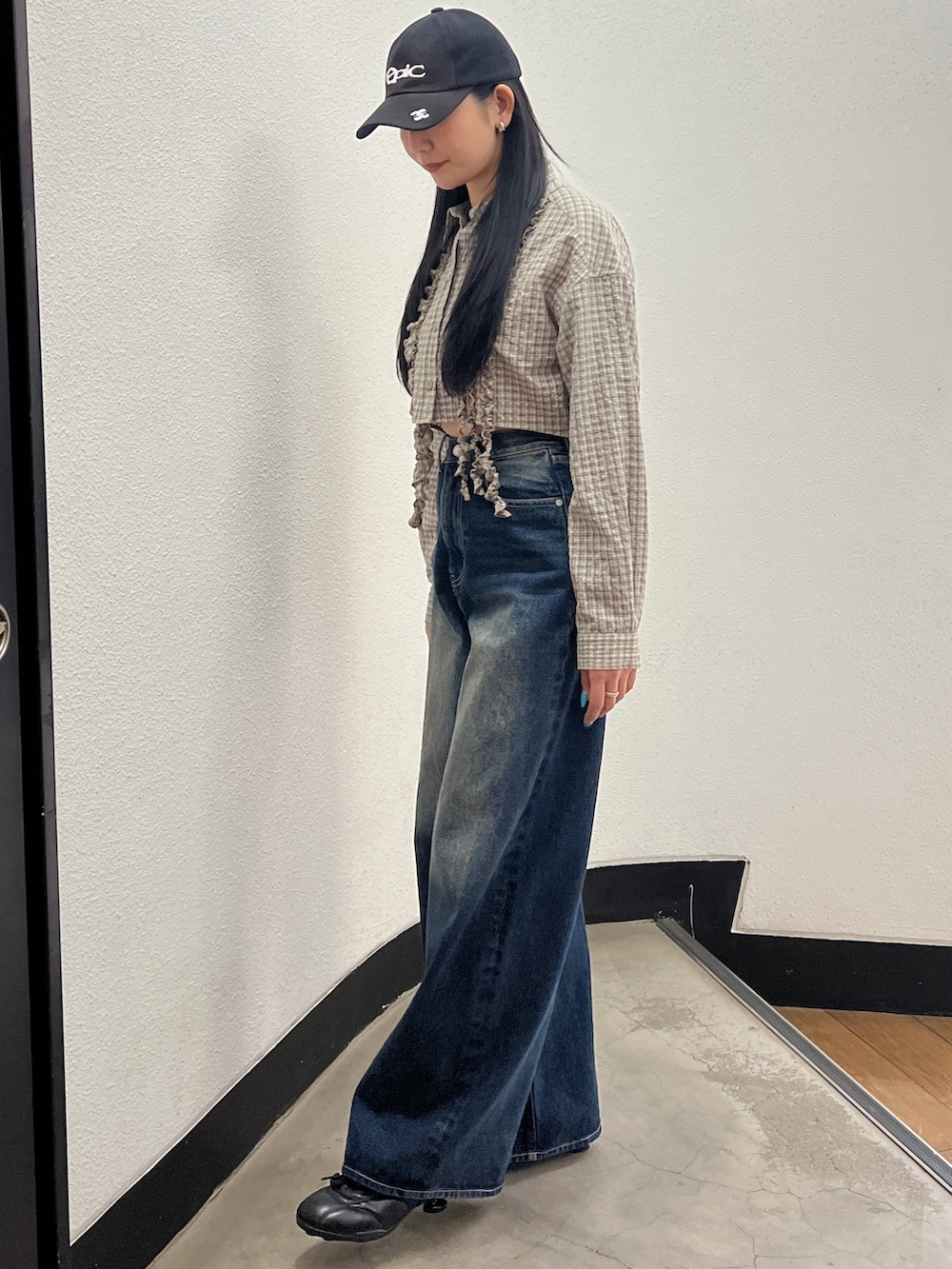 ベージュ系のシャツ/ブラウス、ブルー系のデニムパンツ、ブラック系のスニーカーを着用したレディースの春コーディネートの3枚目の写真