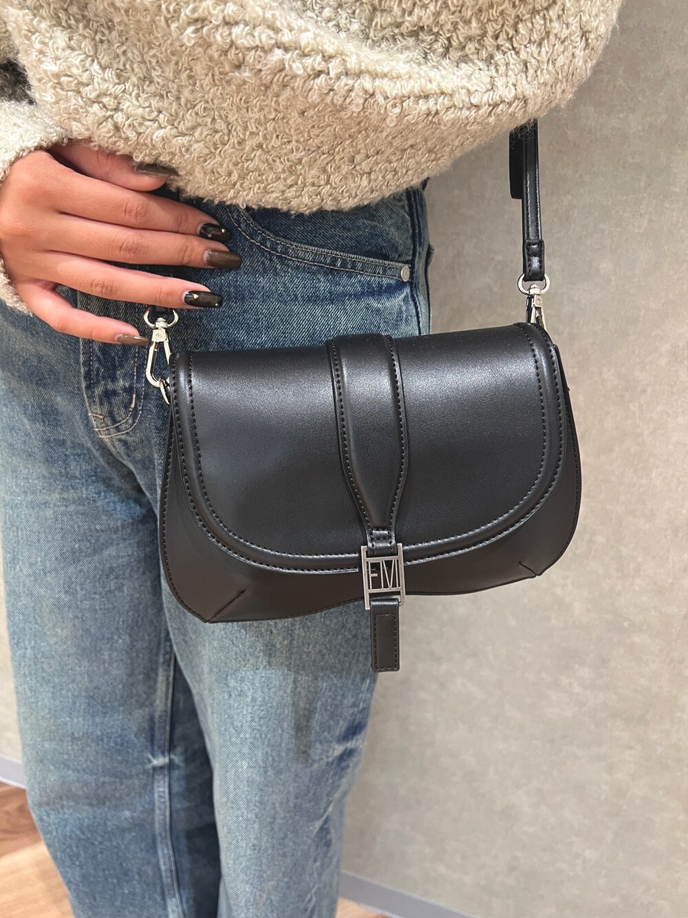 グレー系のニット/セーター、ブルー系のデニムパンツ、ホワイト系のブーツを着用したレディースの秋コーディネートの6枚目の写真