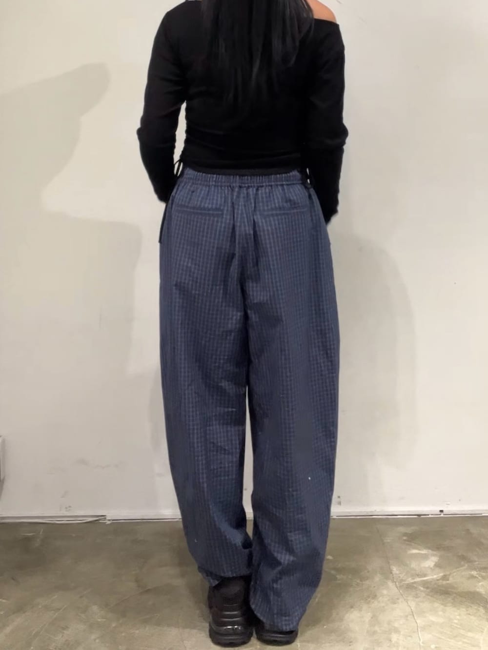 ブルー系のその他パンツ、ブラック系のTシャツ/カットソー、ブラック系のスニーカーを着用したレディースの春コーディネートの3枚目の写真