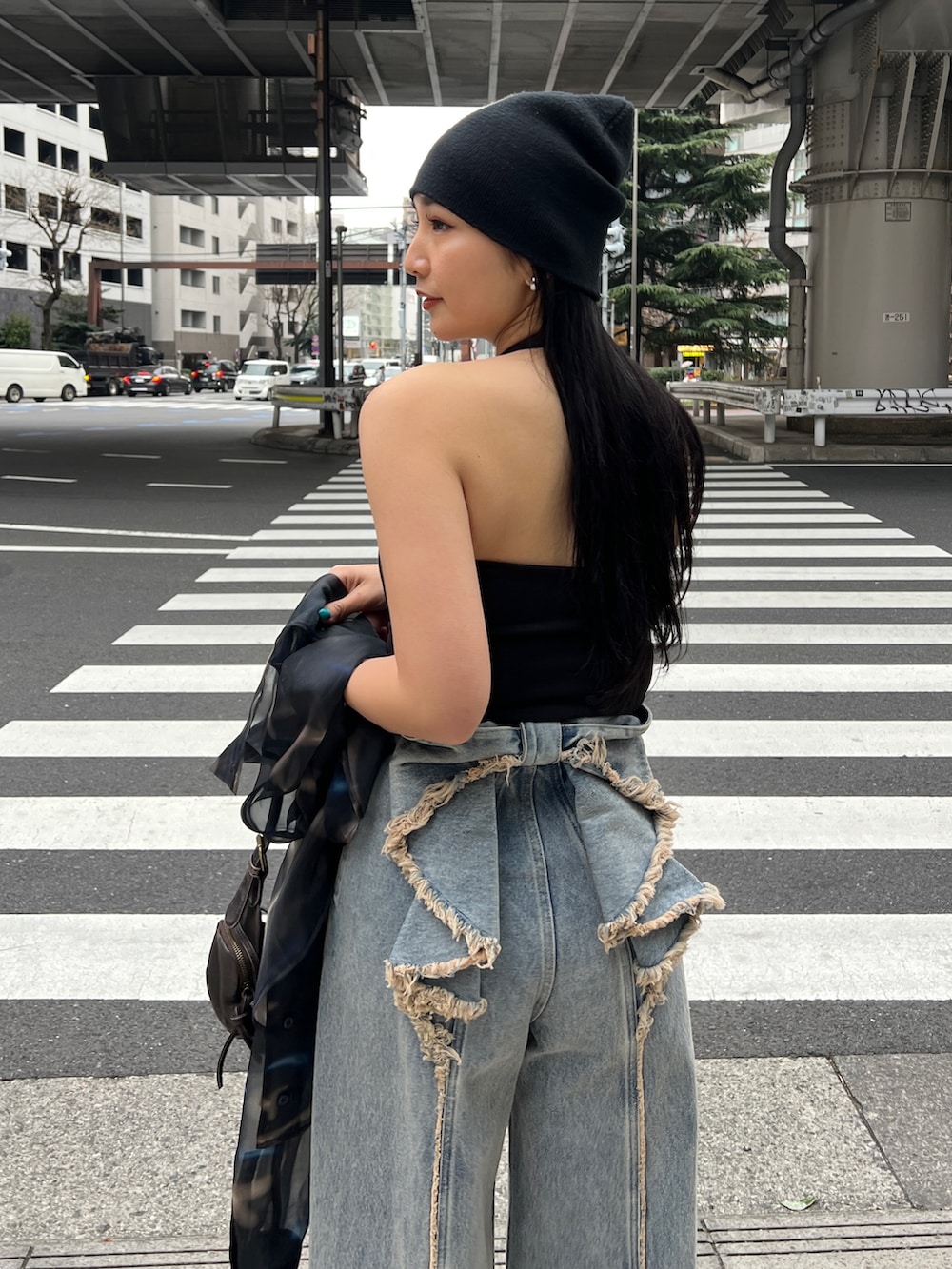 ブラック系のタンクトップ、ブルー系のデニムパンツを着用したレディースの春コーディネートの2枚目の写真