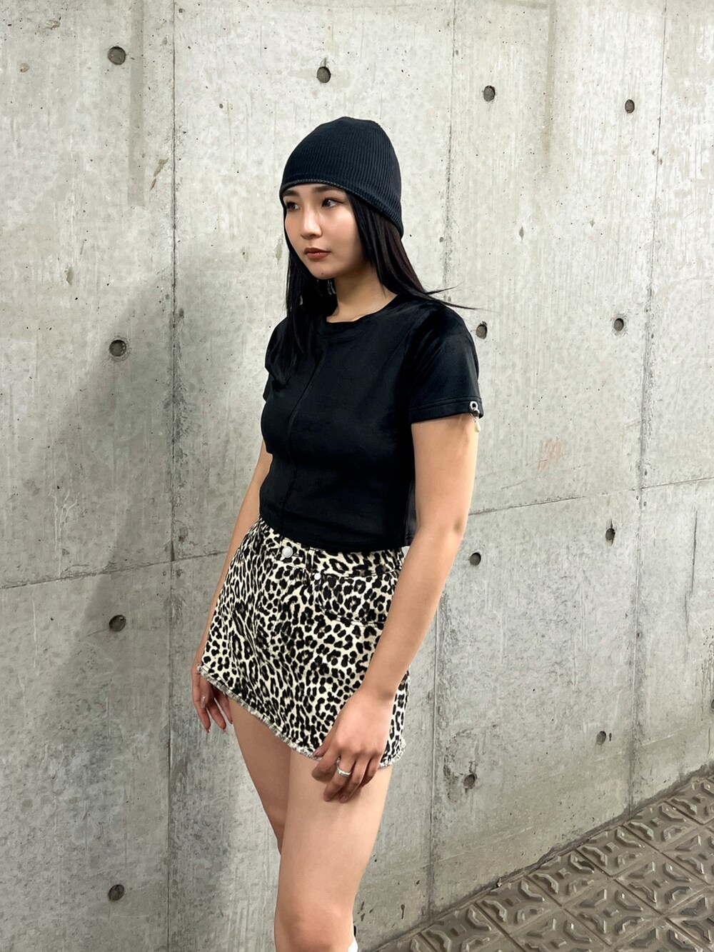 ホワイト系のスカート、ブラック系のTシャツ/カットソー、ブラック系のブーツを着用したレディースの夏コーディネートの4枚目の写真